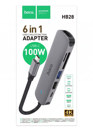 Caja del hub USB-C 6 en 1 Hoco HB28 de aluminio gris con puertos HDMI, USB y lector de tarjetas SD.