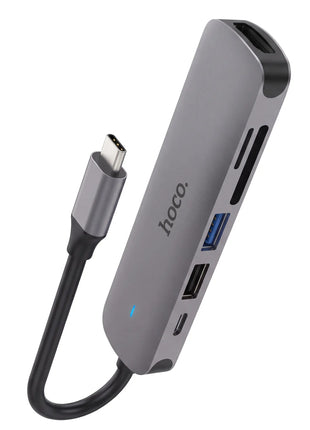 Hub USB-C Hoco HB28 en aluminio gris espacial con puertos USB, HDMI, ranuras para tarjetas y cable integrado.